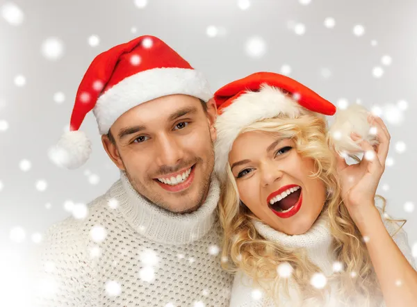 Casal de família em camisolas e chapéus de Papai Noel — Fotografia de Stock