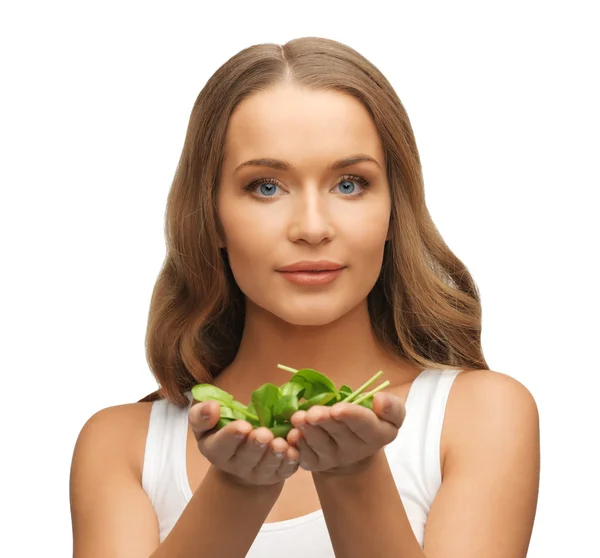 Woman with spinach leaves on palms — Stock Photo, Image