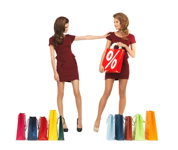 Nastoletnie dziewczyny w czerwonych sukniach z torby na zakupy — Zdjęcie stockowe