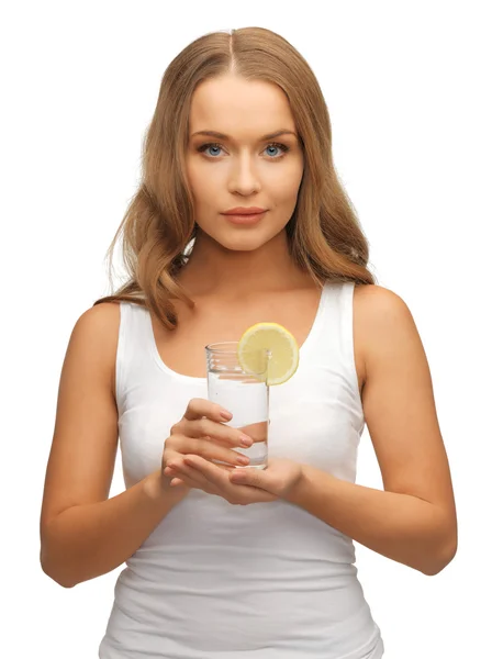 Mulher com fatia de limão em copo de água — Fotografia de Stock