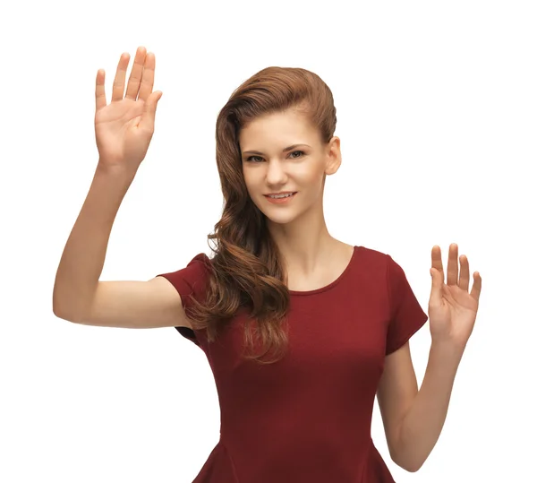 Girl in red dress working with something imaginary — Stock Photo, Image