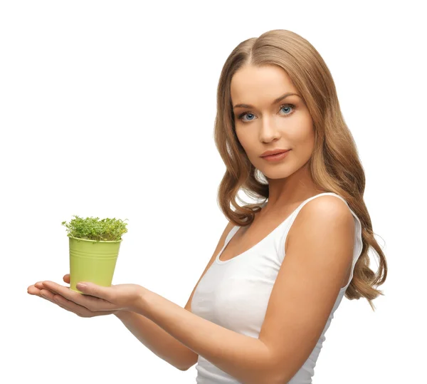 Kvinna med grönt gräs i kruka — Stockfoto
