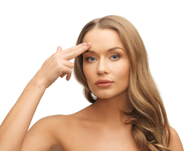 Beautiful woman pointing to forehead — Stock Photo, Image