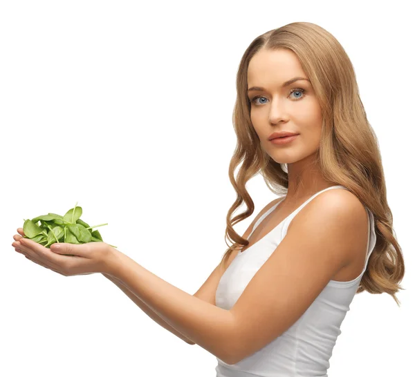 Woman with spinach leaves on palms — Stock Photo, Image