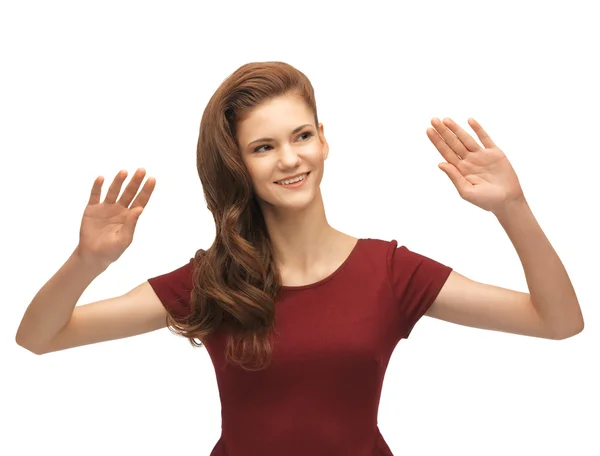 Girl in red dress working with something imaginary — Stock Photo, Image
