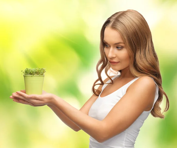 Woman with green grass in pot — Stock Photo, Image