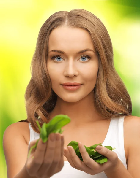 Woman with spinach leaves on palms — Stock Photo, Image