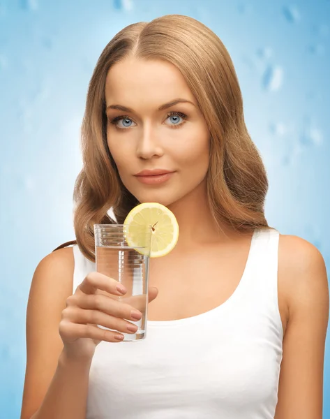 Frau mit Zitronenscheibe auf Glas Wasser — Stockfoto