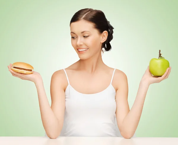 Frau mit Hamburger und Apfel — Stockfoto