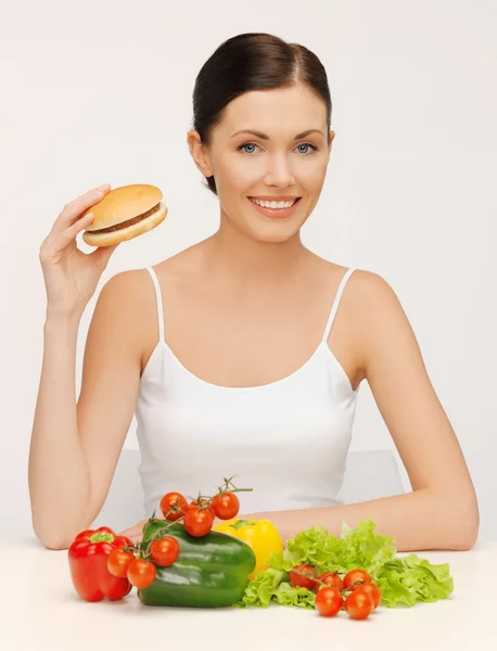 Mulher com hambúrguer e legumes — Fotografia de Stock