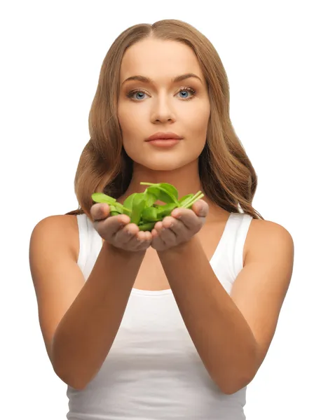 Woman with spinach leaves on palms — Stock Photo, Image