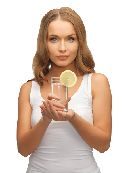 Женщина с ломтиком лимона на стакане воды — стоковое фото