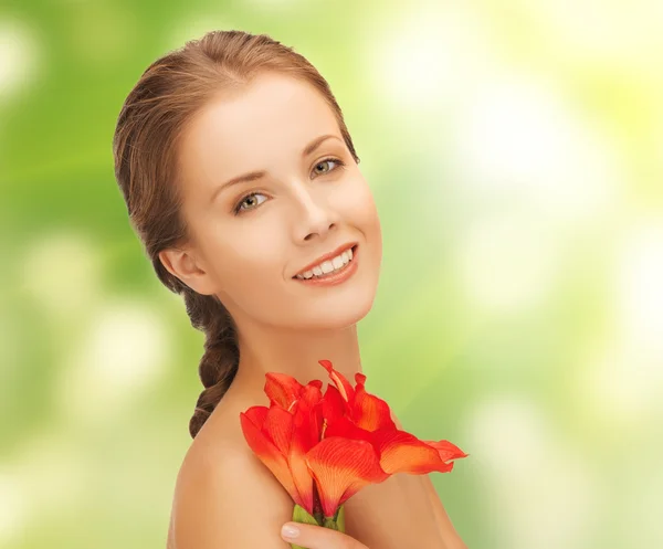 Mulher encantadora com flor de lírio vermelho — Fotografia de Stock