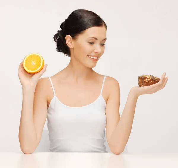 Vrouw met cake en oranje — Stockfoto