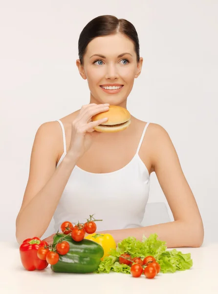 Femme avec hamburger et légumes — Photo