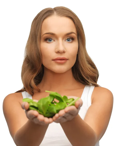 Woman with spinach leaves on palms — Stock Photo, Image