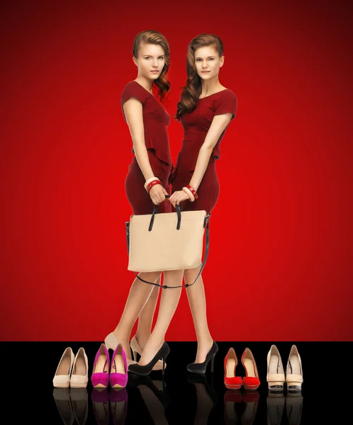 Two teenage girls in red dresses with bag — Stock Photo, Image