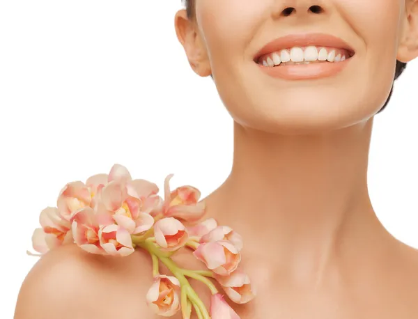 Mujer sonriente con flor de orquídea en el hombro —  Fotos de Stock