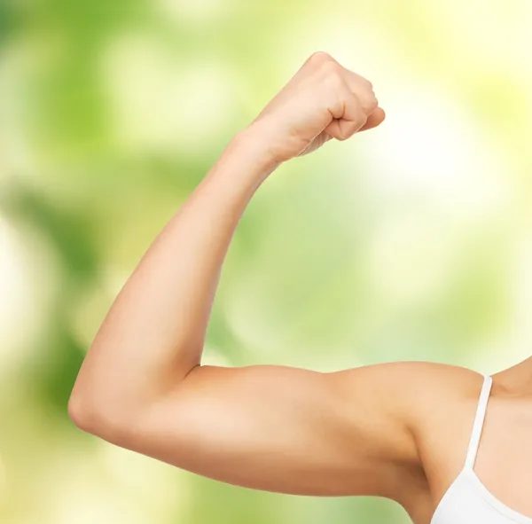 Sporty woman flexing her biceps — Stock Photo, Image