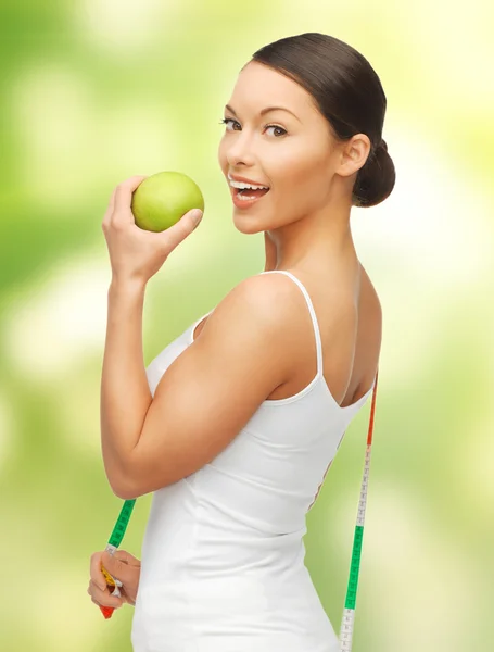Женщина с измерительной лентой и яблоком — стоковое фото