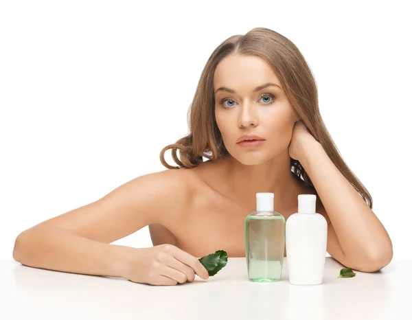 Kvinna med kosmetika flaskor — Stockfoto