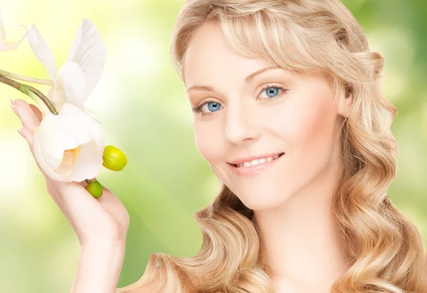 Hermosa mujer con flor de orquídea — Foto de Stock