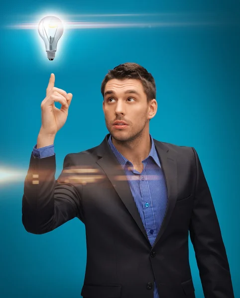 Man in suit with light bulb — Stock Photo, Image