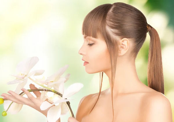 Bela mulher com flor de orquídea — Fotografia de Stock