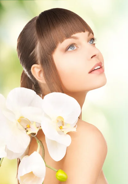 Hermosa mujer con flor de orquídea — Foto de Stock