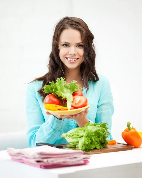 Mujer en la cocina cortando verduras — Foto de Stock