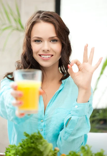 Donna in possesso di un bicchiere di succo e mostrando segno ok — Foto Stock