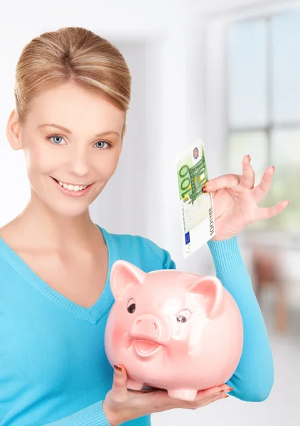 Mulher encantadora com banco porquinho e dinheiro — Fotografia de Stock