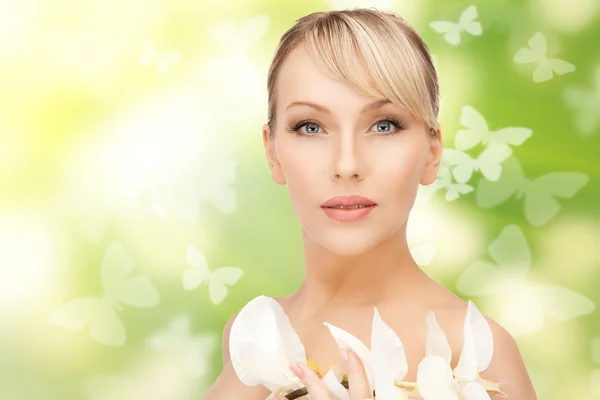 Hermosa mujer con flor de orquídea y mariposas —  Fotos de Stock