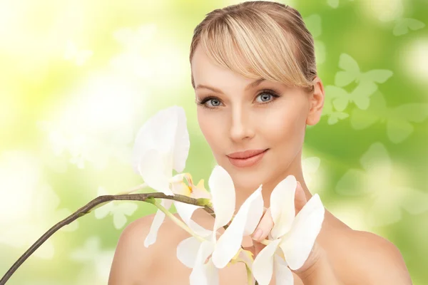 Schöne Frau mit Orchideenblume und Schmetterlingen — Stockfoto