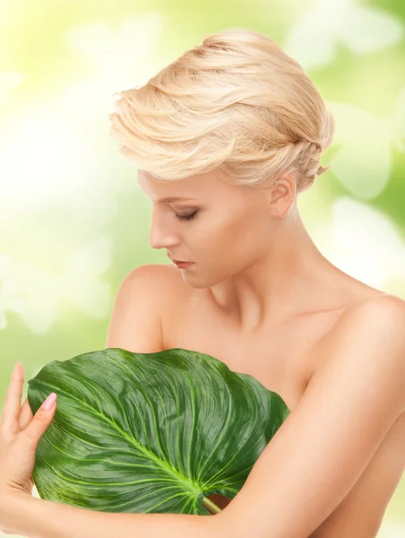 Женщина с зеленым листом и бабочками — стоковое фото