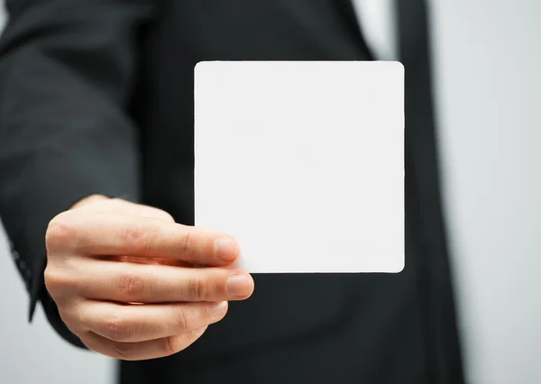 Man in suit holding blank card — Stock Photo, Image