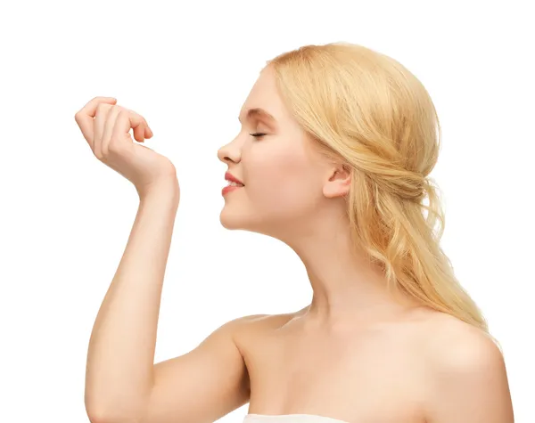 Young girl smelling pefrume on her hand — Stock Photo, Image