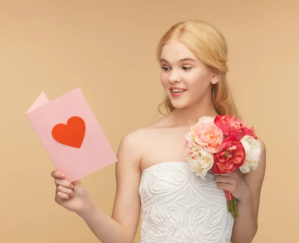 Junge Frau mit Blumen und Postkarte — Stockfoto