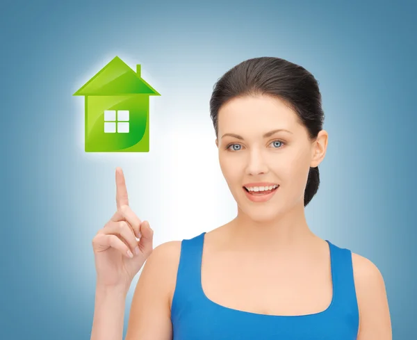 Woman wijzend haar vinger op groen huis — Stockfoto