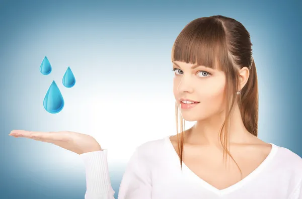 Женщина показывает голубые капли воды — стоковое фото