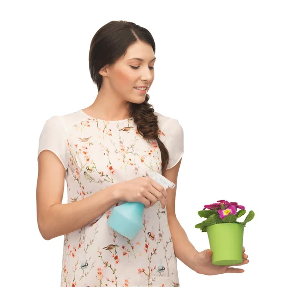 Mujer sosteniendo maceta con flor y botella de spray —  Fotos de Stock