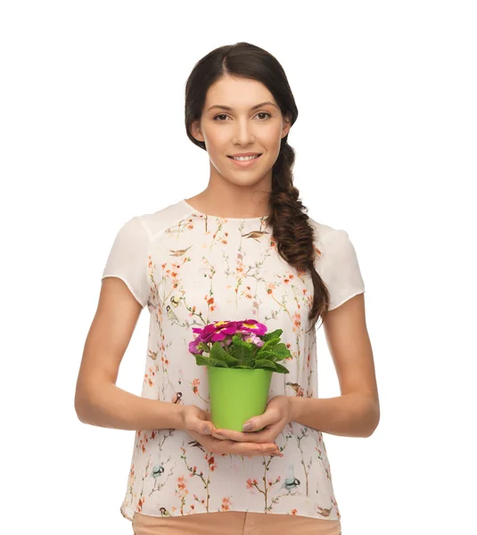Prachtige huisvrouw met bloem in pot — Stockfoto