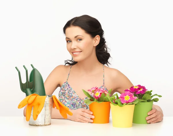 Housewife with flower in pot and gardening set — Stock Photo, Image