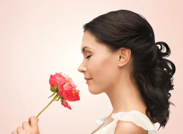 Sorrindo mulher cheirando flor — Fotografia de Stock