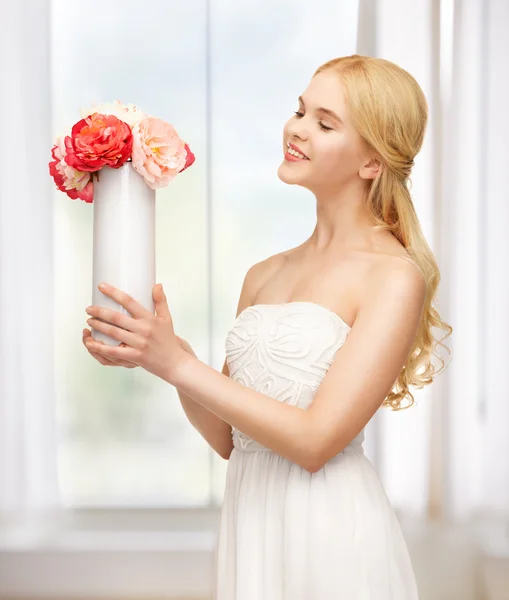 Woman with vase of flowers — Stock Photo, Image