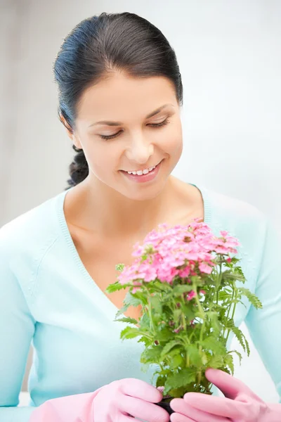 Linda dona de casa com flor no pote — Fotografia de Stock