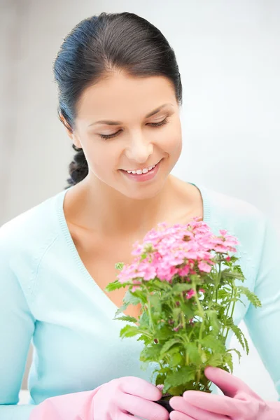 Belle femme au foyer avec fleur en pot — Photo