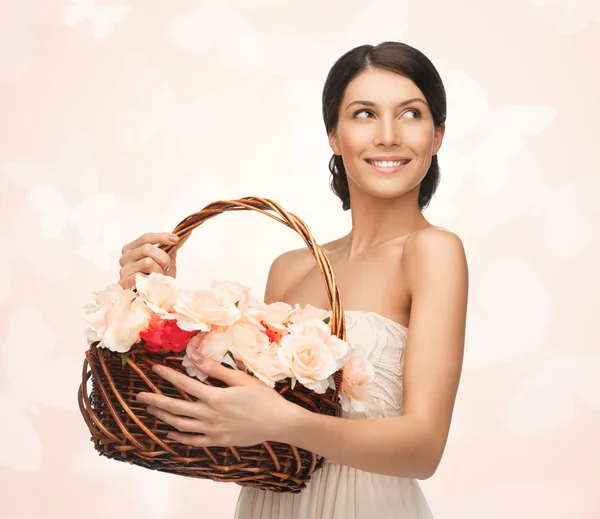 Frau mit Korb voller Blumen — Stockfoto