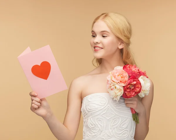 Mujer joven sosteniendo flor y postal — Foto de Stock