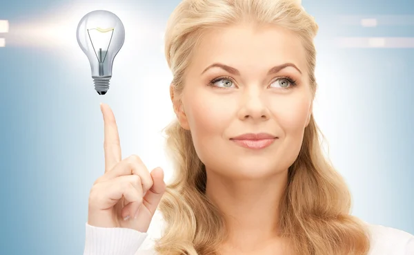 Woman pointing her finger at light bulb Royalty Free Stock Images